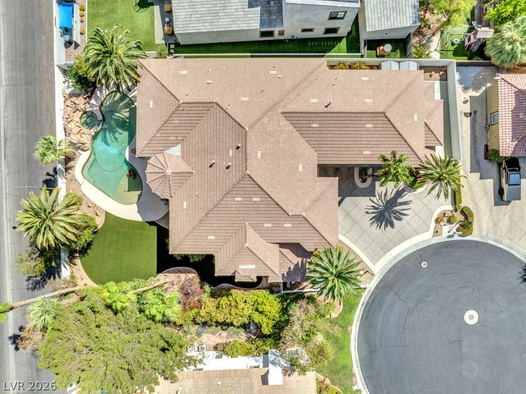 1632 Marbella Ridge Court, Las Vegas, NV 89117 An aerial perspective showcases the tile roof and backyard pool layout of this suburban home.