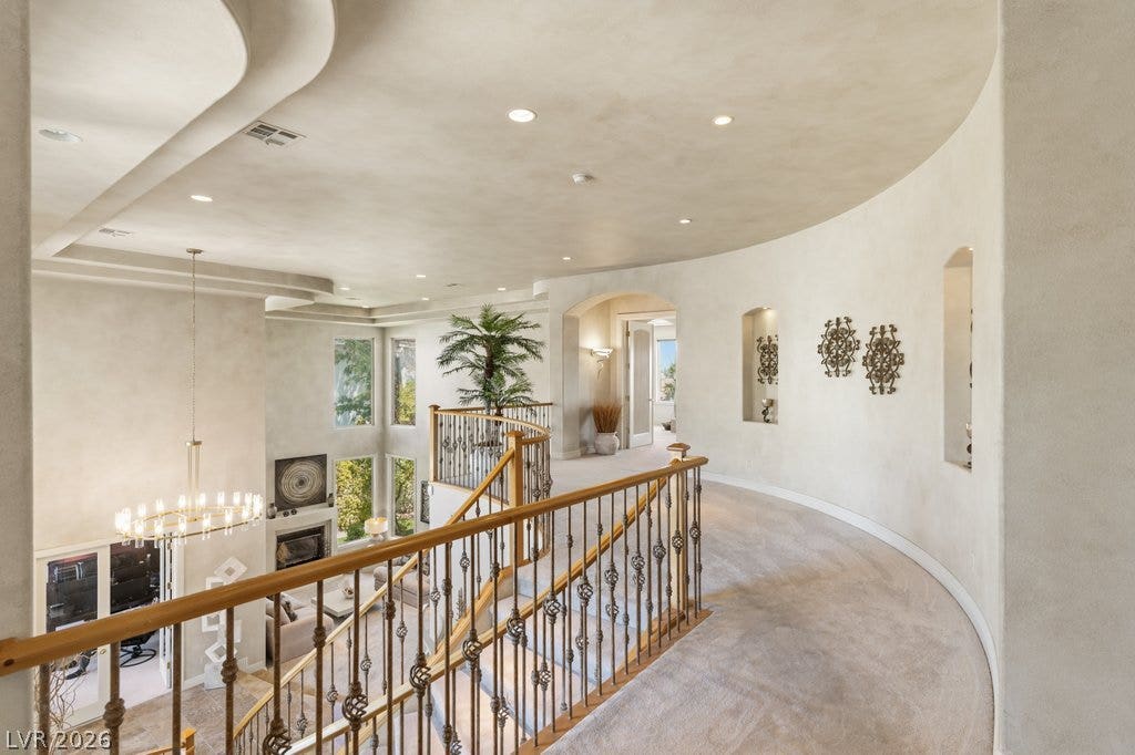 1632 Marbella Ridge Court, Las Vegas, NV 89117 A curved upper hallway with plush carpeting overlooks the living space below.