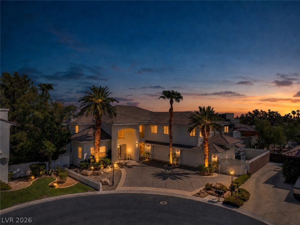 1632 Marbella Ridge Court, Las Vegas, NV 89117 Dramatic sunset skies frame this grand two-story estate with an expansive circular driveway.