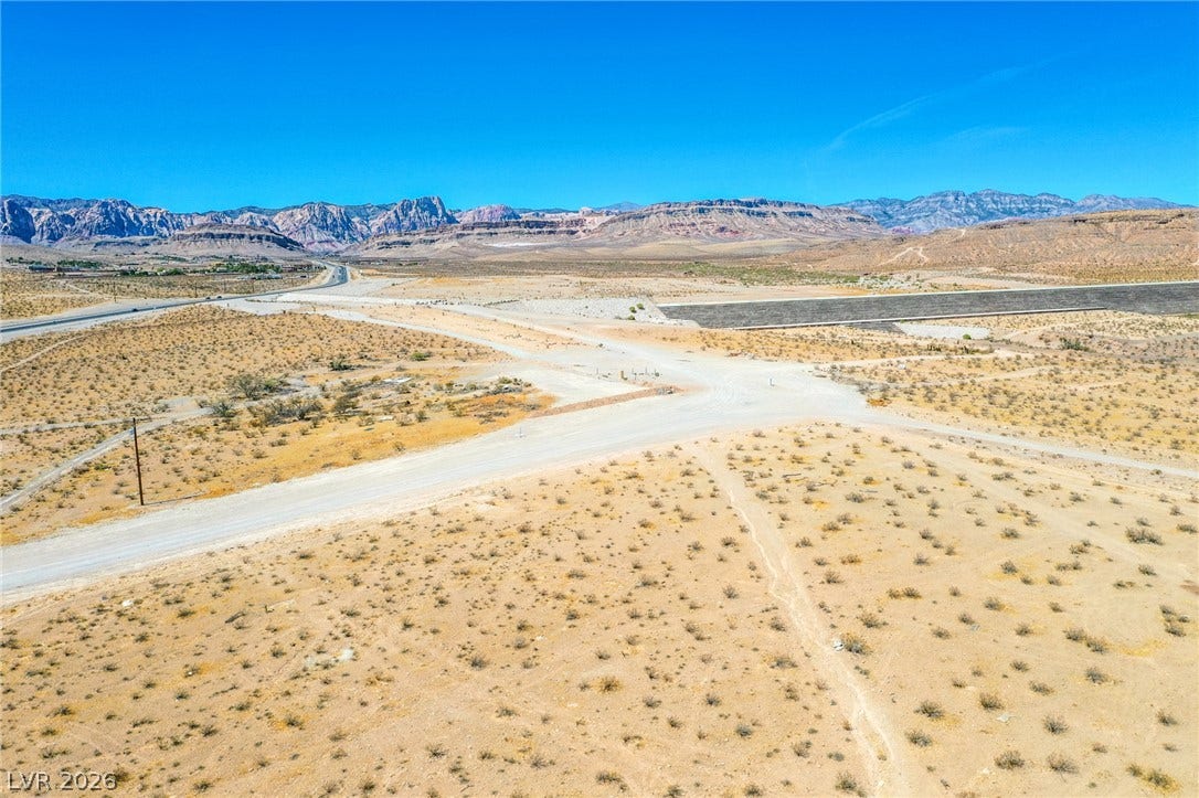 0 SE Corner of Hualapai & Pebble, Las Vegas, NV 89178 Rugged desert terrain frames sweeping panoramas of distant mountain ranges under clear blue skies.