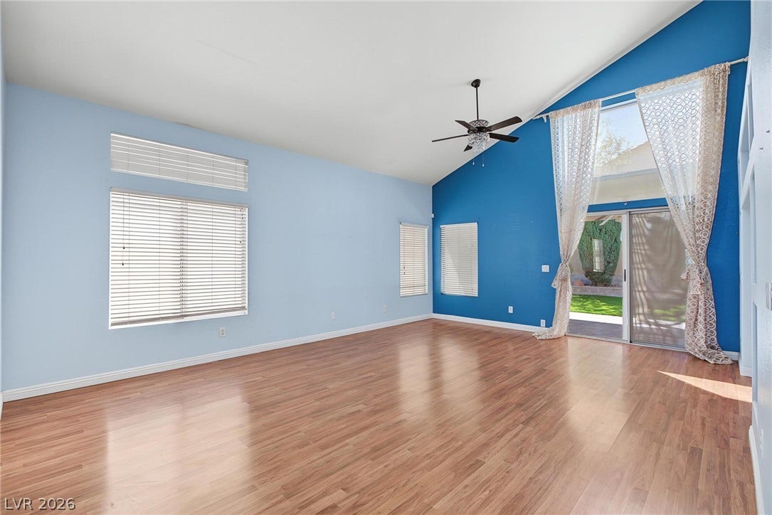 911 Sterling Thorn Court, Las Vegas, NV 89183 Vaulted ceilings and warm wood floors anchor this airy living space with sliding glass doors.