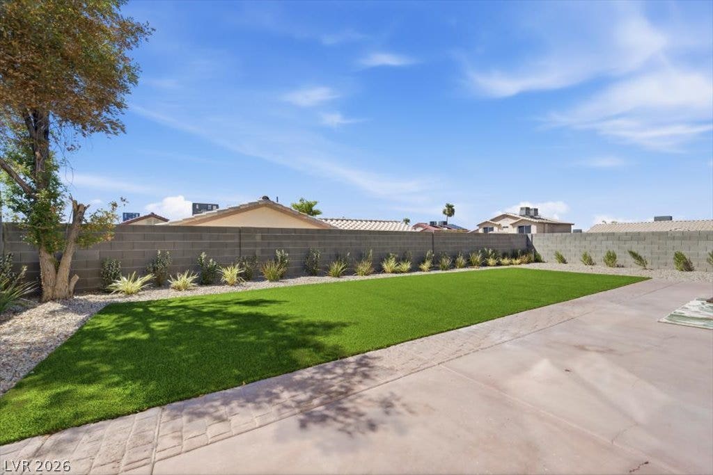 139 Skytop Drive, Henderson, NV 89015 An inviting backyard features a spacious patio, low maintenance synthetic turf, and a secure gated RV entry.