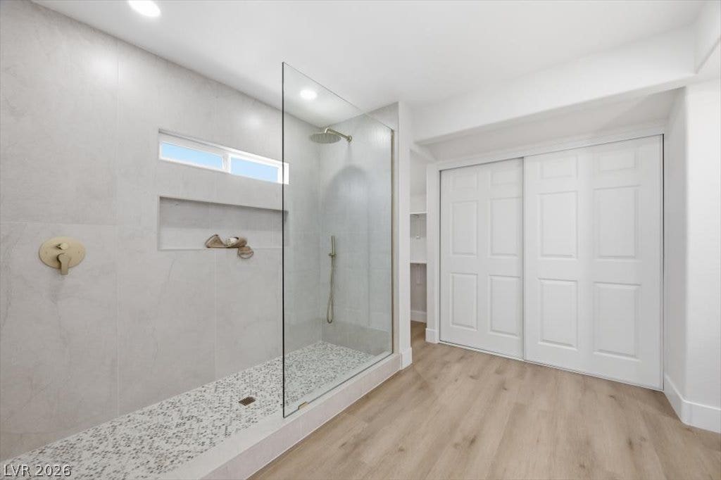 139 Skytop Drive, Henderson, NV 89015 A modern bathroom boasts a sleek glass-paneled shower with elegant tile finishes.