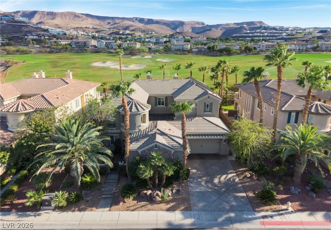 1343 Quiet River Avenue, Henderson, NV 89012 An elegant tile-roofed residence borders a manicured golf course backdropped by sweeping mountain views.