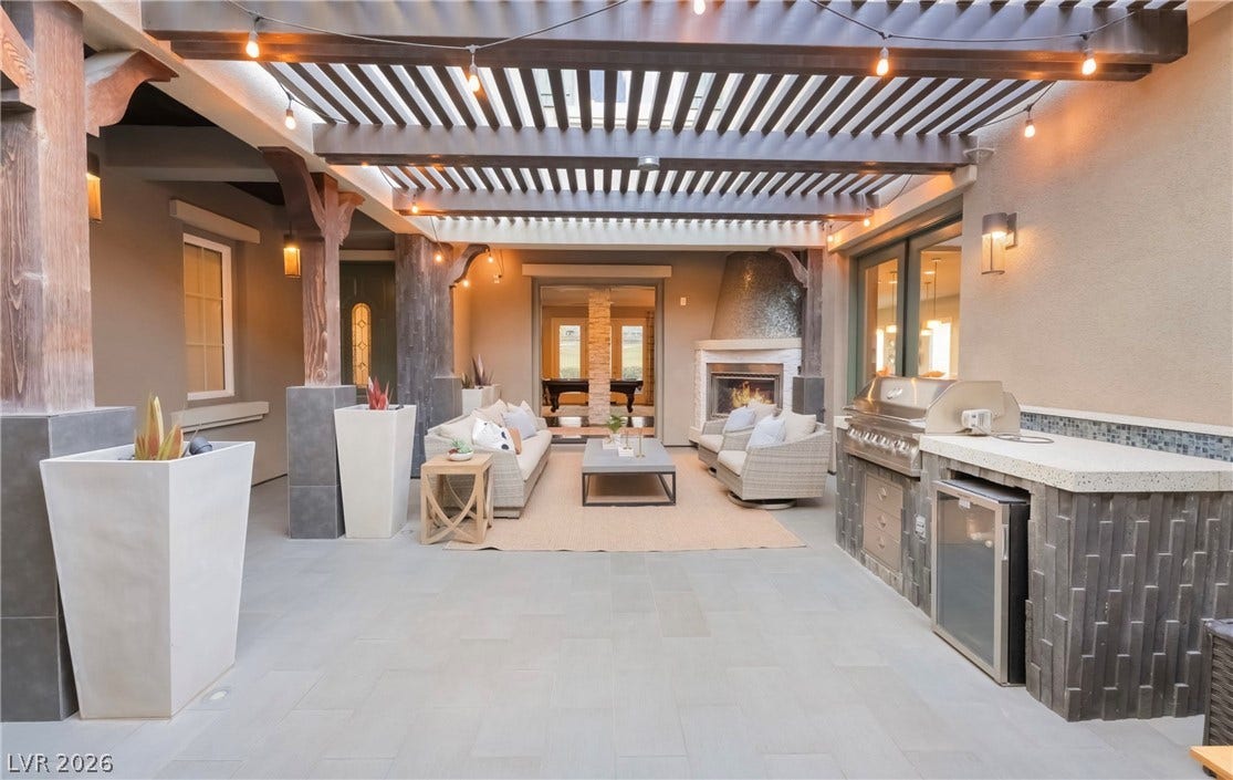 1343 Quiet River Avenue, Henderson, NV 89012 A spacious stone patio features a handsome wooden pergola overhead and an integrated outdoor kitchen.