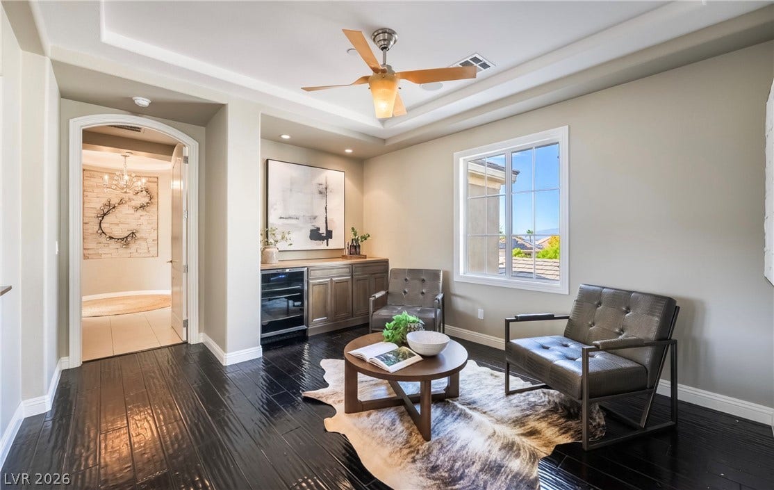 1343 Quiet River Avenue, Henderson, NV 89012 Rich dark wood flooring and a recessed tray ceiling define this versatile living area.