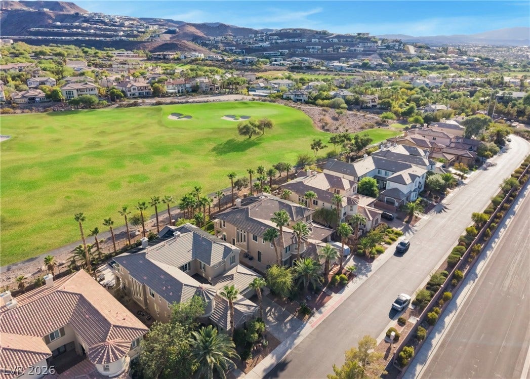 1343 Quiet River Avenue, Henderson, NV 89012 An aerial perspective showcases a row of modern homes bordering a manicured green fairway.