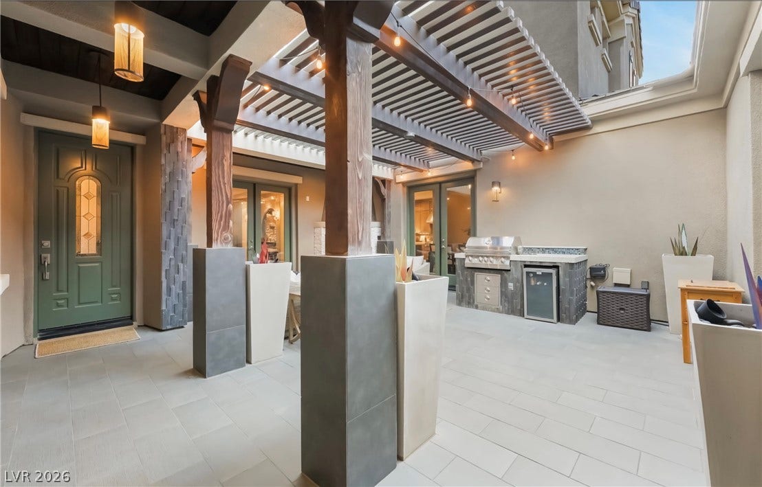 1343 Quiet River Avenue, Henderson, NV 89012 A secluded stone courtyard offers a built-in outdoor kitchen under a heavy-timber pergola.