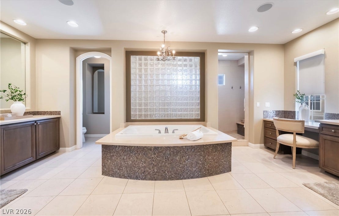 1343 Quiet River Avenue, Henderson, NV 89012 Tiled flooring and a mosaic-wrapped soaking tub anchor this spacious main bathroom.
