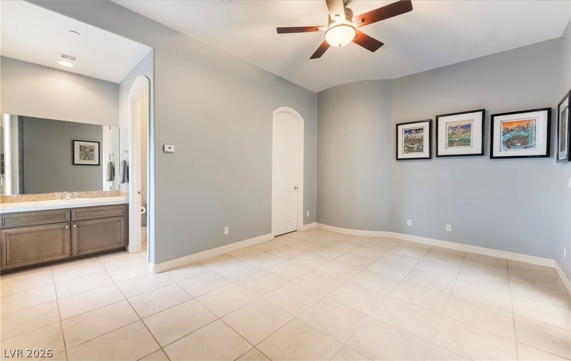 1343 Quiet River Avenue, Henderson, NV 89012 A spacious room features tile flooring, arched doorways, and an adjoining vanity alcove.