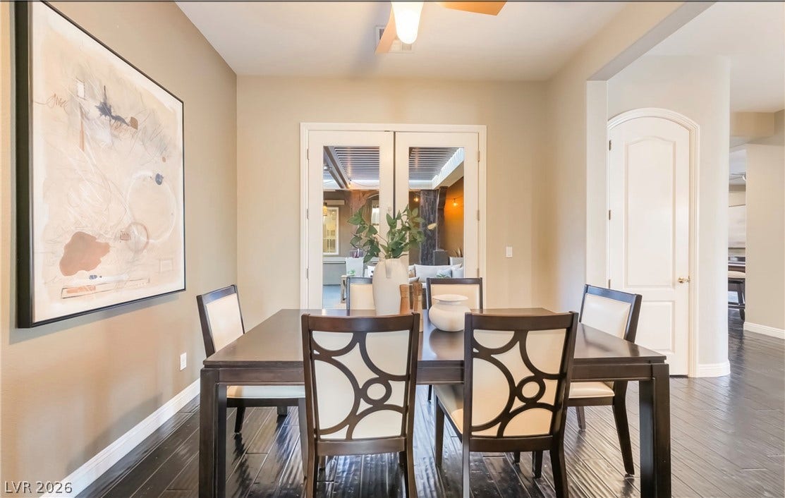 1343 Quiet River Avenue, Henderson, NV 89012 Rich dark wood floors ground the space, leading toward glass-paned doors that open to the patio.