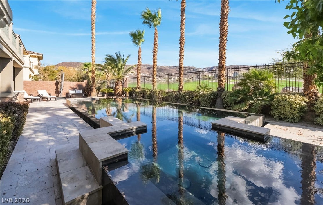 1343 Quiet River Avenue, Henderson, NV 89012 Palm trees frame a sparkling swimming pool overlooking the nearby golf course.