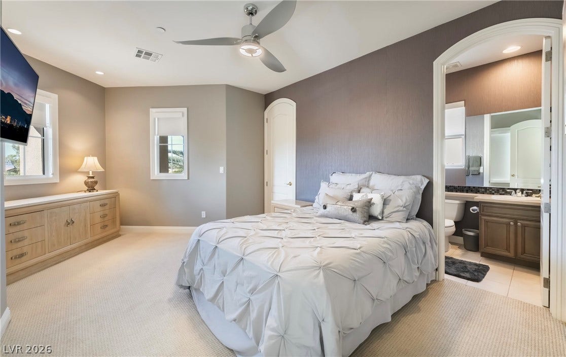 1343 Quiet River Avenue, Henderson, NV 89012 An arched doorway links this comfortable bedroom to an adjacent private bathroom.