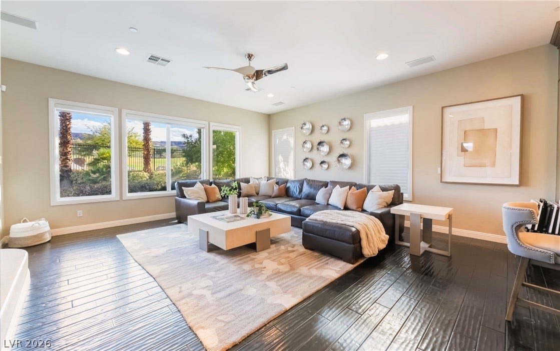 1343 Quiet River Avenue, Henderson, NV 89012 Rich dark wood floors and large picture windows define this welcoming gathering space.