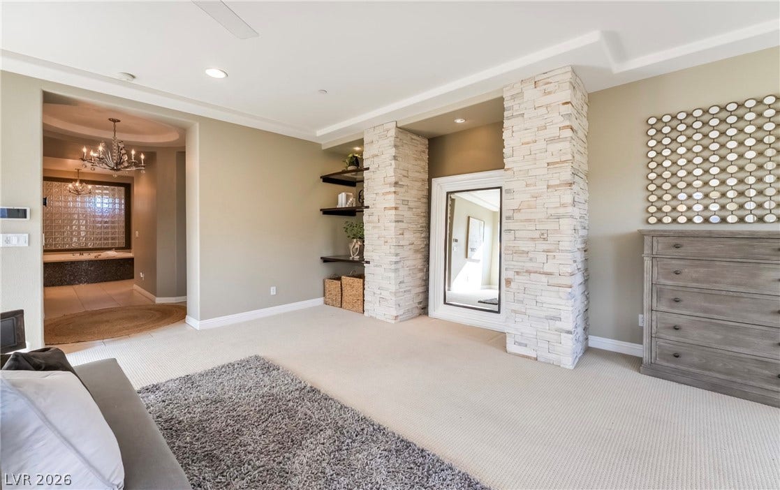 1343 Quiet River Avenue, Henderson, NV 89012 Stone pillars flank a recessed niche in this carpeted master bedroom with recessed lighting.