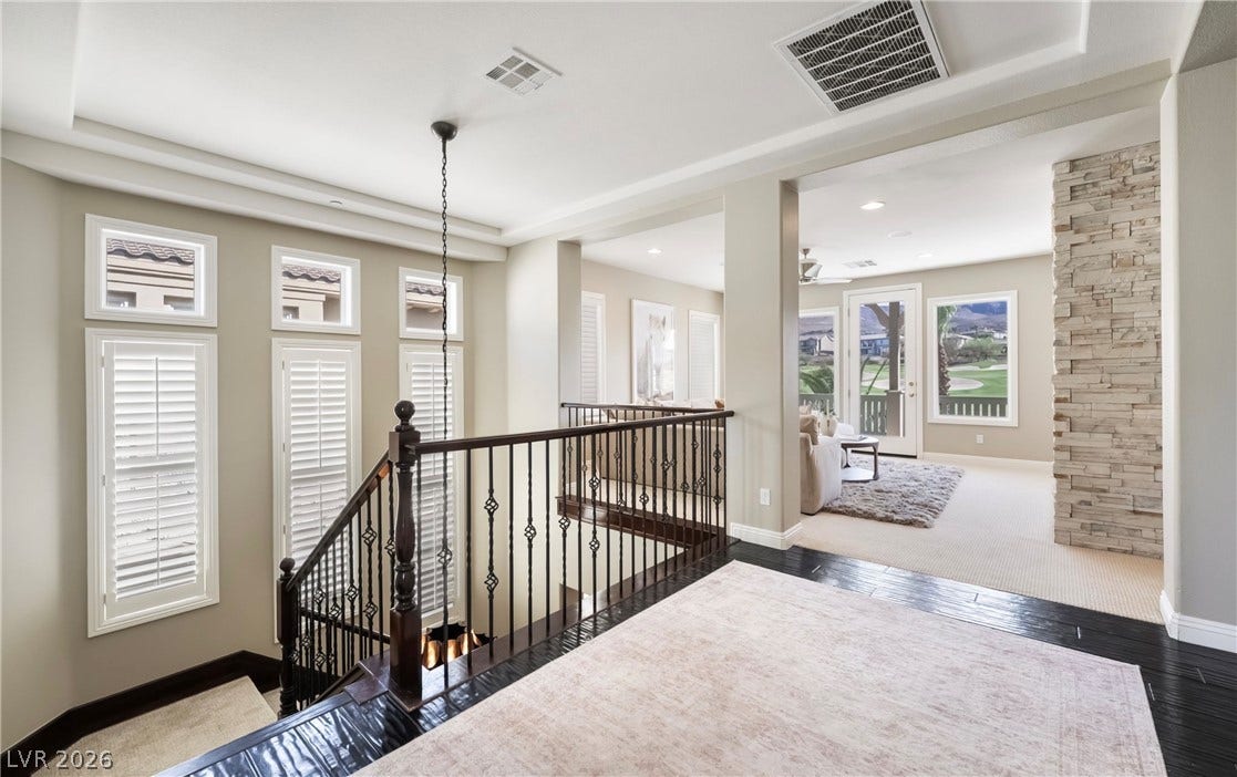 1343 Quiet River Avenue, Henderson, NV 89012 Gleaming hardwood floors and a wrought-iron staircase define this open upper-level landing.