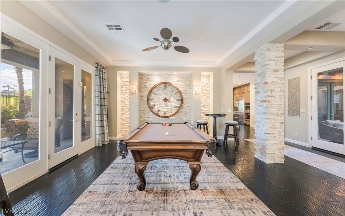 1343 Quiet River Avenue, Henderson, NV 89012 Rich dark wood flooring and a stone-accented pillar define this elegant recreation space.
