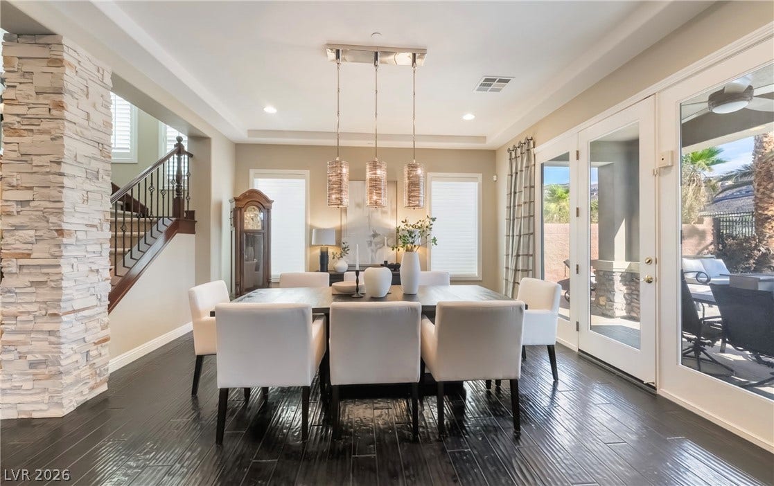 1343 Quiet River Avenue, Henderson, NV 89012 Gleaming dark hardwood flooring and a textured stone pillar define this sophisticated formal dining area.