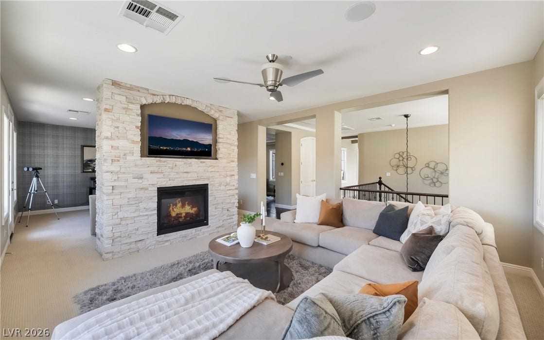 1343 Quiet River Avenue, Henderson, NV 89012 A stone fireplace anchors the living space under recessed lighting.