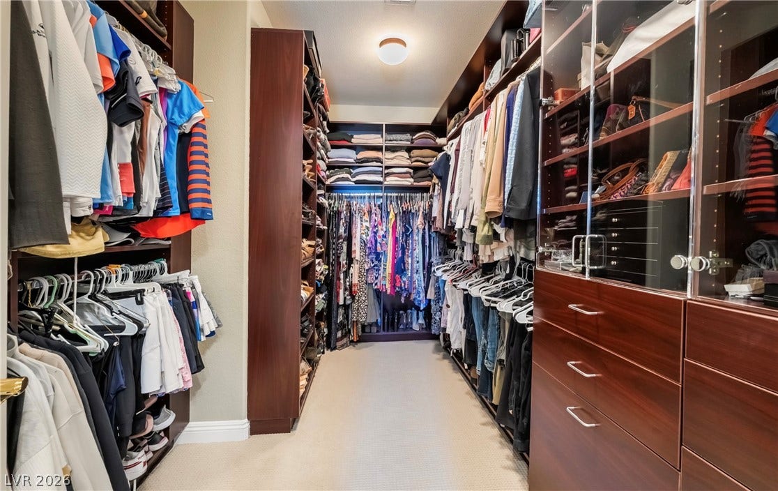 1343 Quiet River Avenue, Henderson, NV 89012 Custom wood shelving and glass-front cabinets maximize organization within this large walk-in closet.