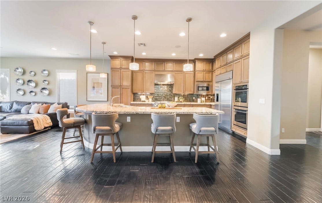 1343 Quiet River Avenue, Henderson, NV 89012 Rich dark wood floors ground this open kitchen anchored by a curved granite island.