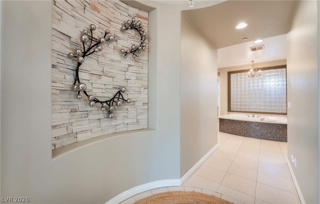 1343 Quiet River Avenue, Henderson, NV 89012 A curved entryway with tiled flooring leads toward a bathroom featuring a large soaking tub.