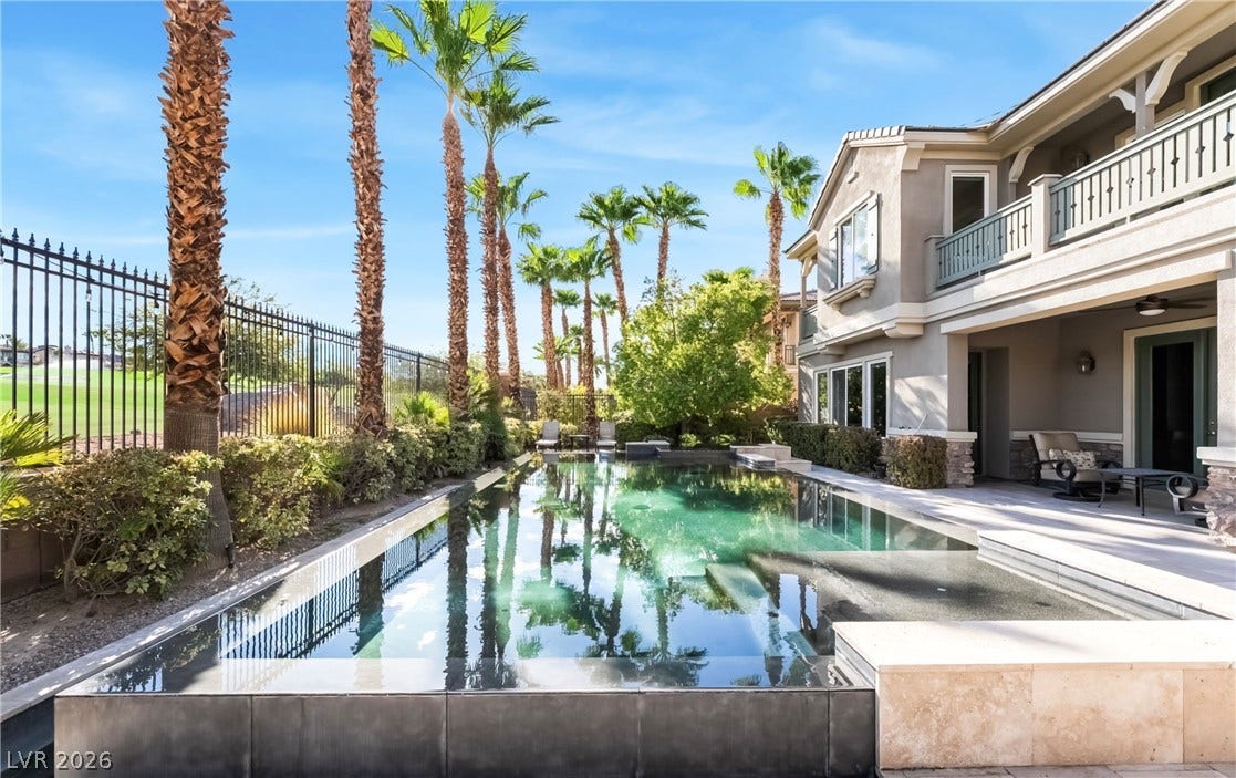 1343 Quiet River Avenue, Henderson, NV 89012 Towering palm trees frame a tranquil swimming pool alongside a covered back patio.