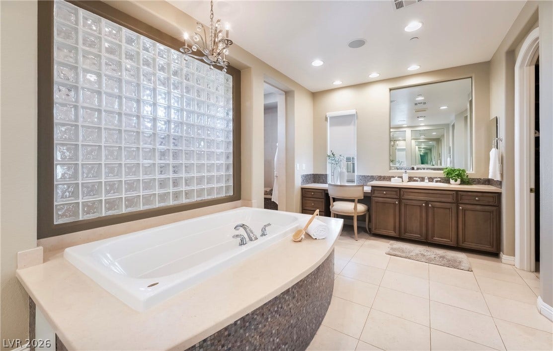 1343 Quiet River Avenue, Henderson, NV 89012 A built-in soaking tub anchors this tile-floored bathroom featuring a double vanity.