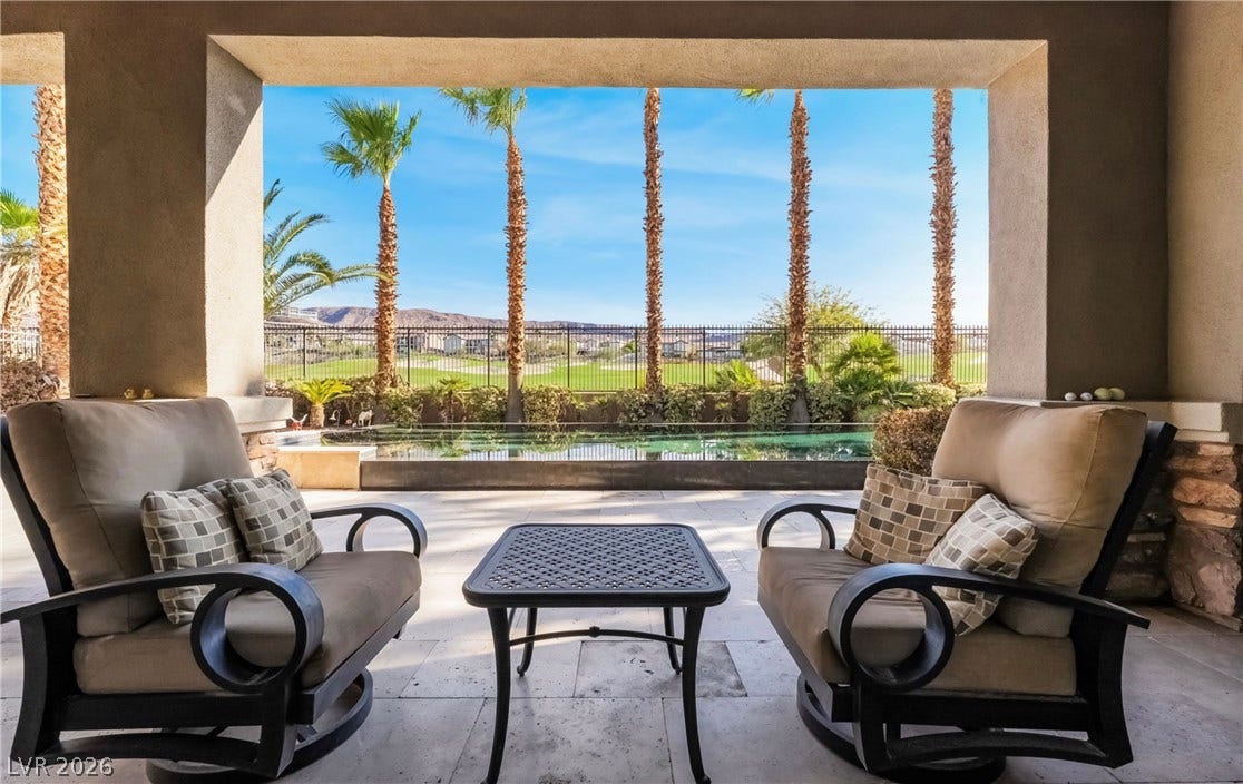 1343 Quiet River Avenue, Henderson, NV 89012 Sheltered outdoor living space frames views of the sparkling swimming pool and distant mountains.