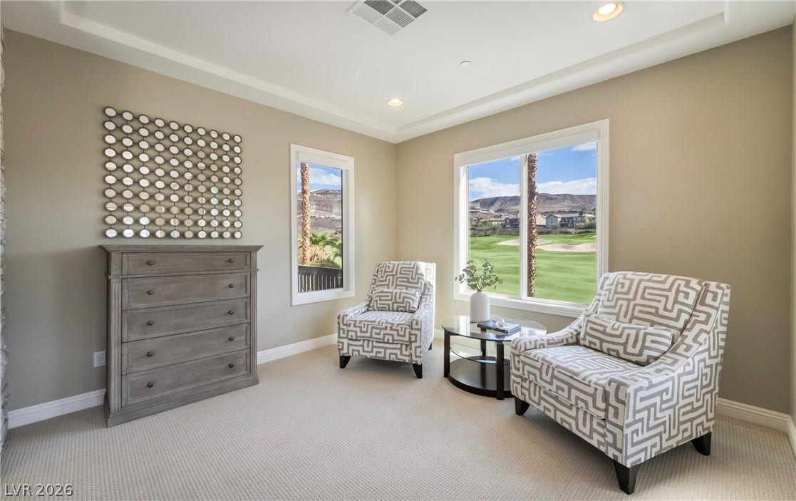 1343 Quiet River Avenue, Henderson, NV 89012 A tray ceiling and neutral carpeting elevate this comfortable seating area overlooking the golf course.