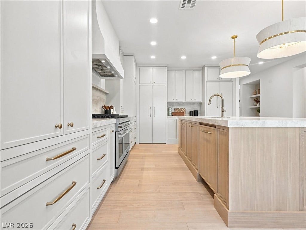 Gleaming hardwood floors and a spacious island anchor this expertly crafted culinary space.