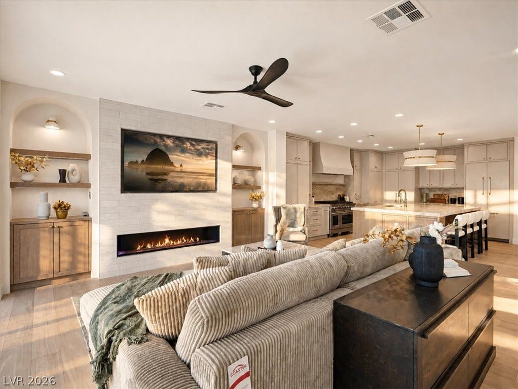 An open floorplan design seamlessly connects the fireplace-warmed living room to the gourmet kitchen.