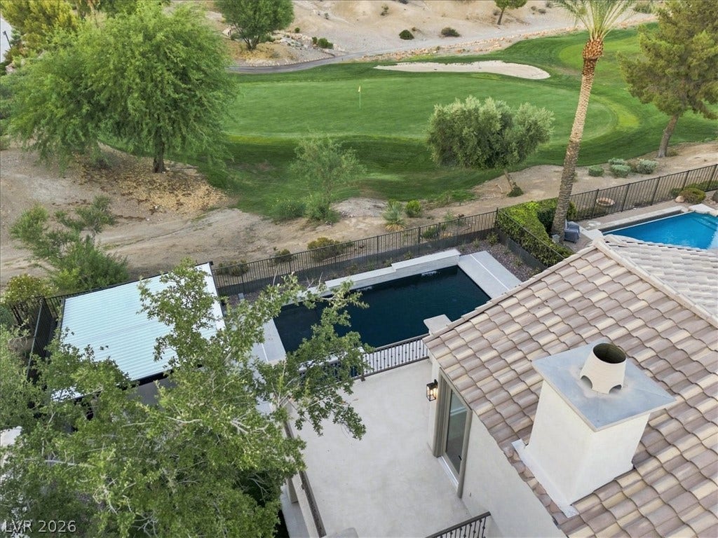 An aerial perspective showcases a private pool alongside the sprawling fairways of a golf course.