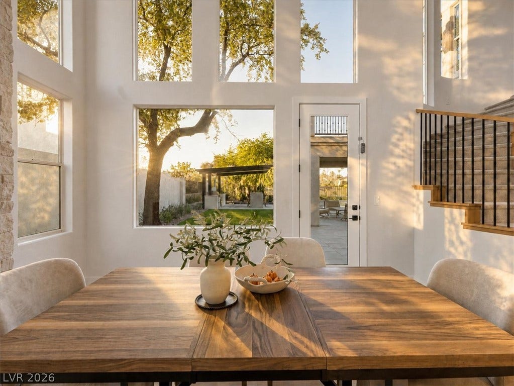 Towering windows frame tranquil backyard views from this light-filled dining space.