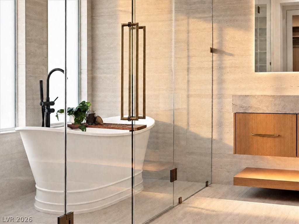 Natural stone walls and a freestanding tub create a serene spa experience.