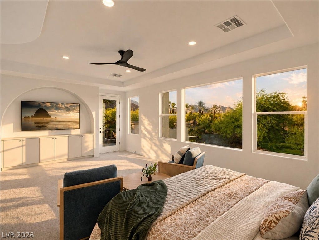 Large windows frame picturesque sunset views in this bedroom with a recessed media niche.