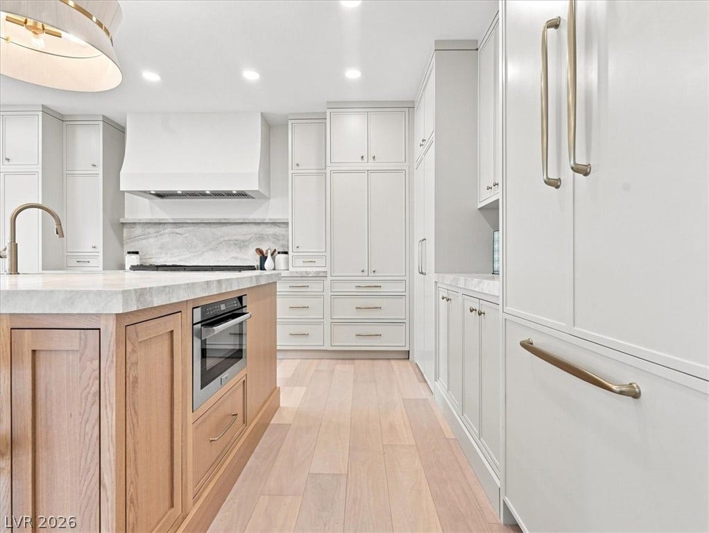 Hardwood floors and custom cabinetry define this modern kitchen layout.