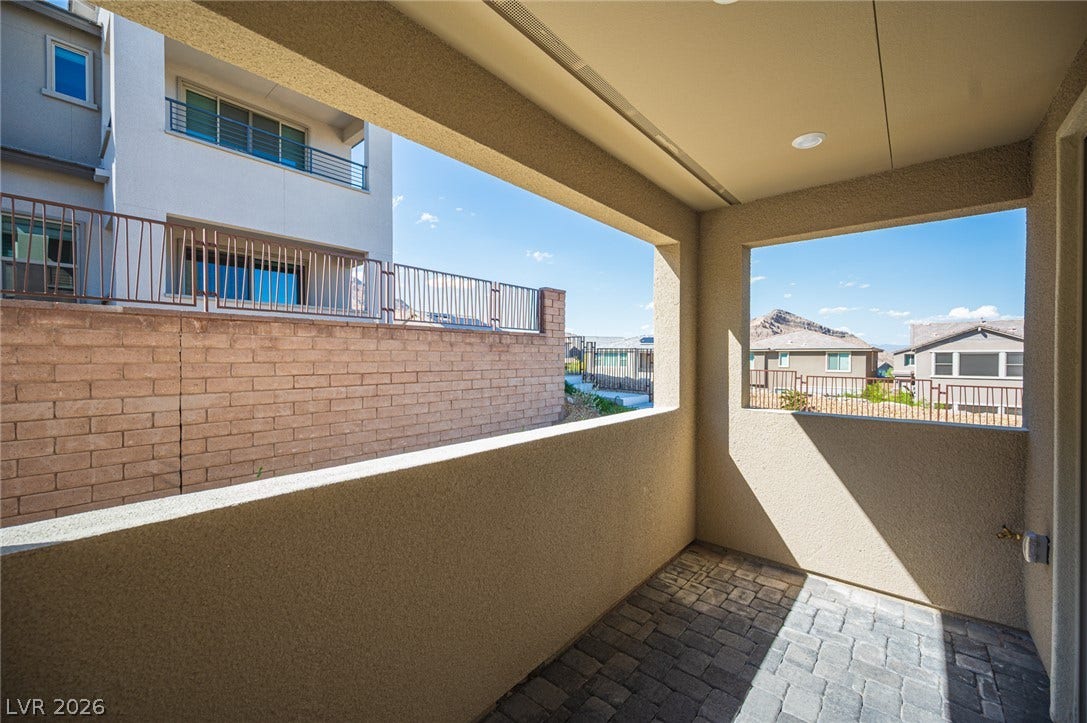 2545 Monolith Street, Las Vegas, NV 89138 A covered patio with stone pavers framed by stucco walls captures distant mountain views.