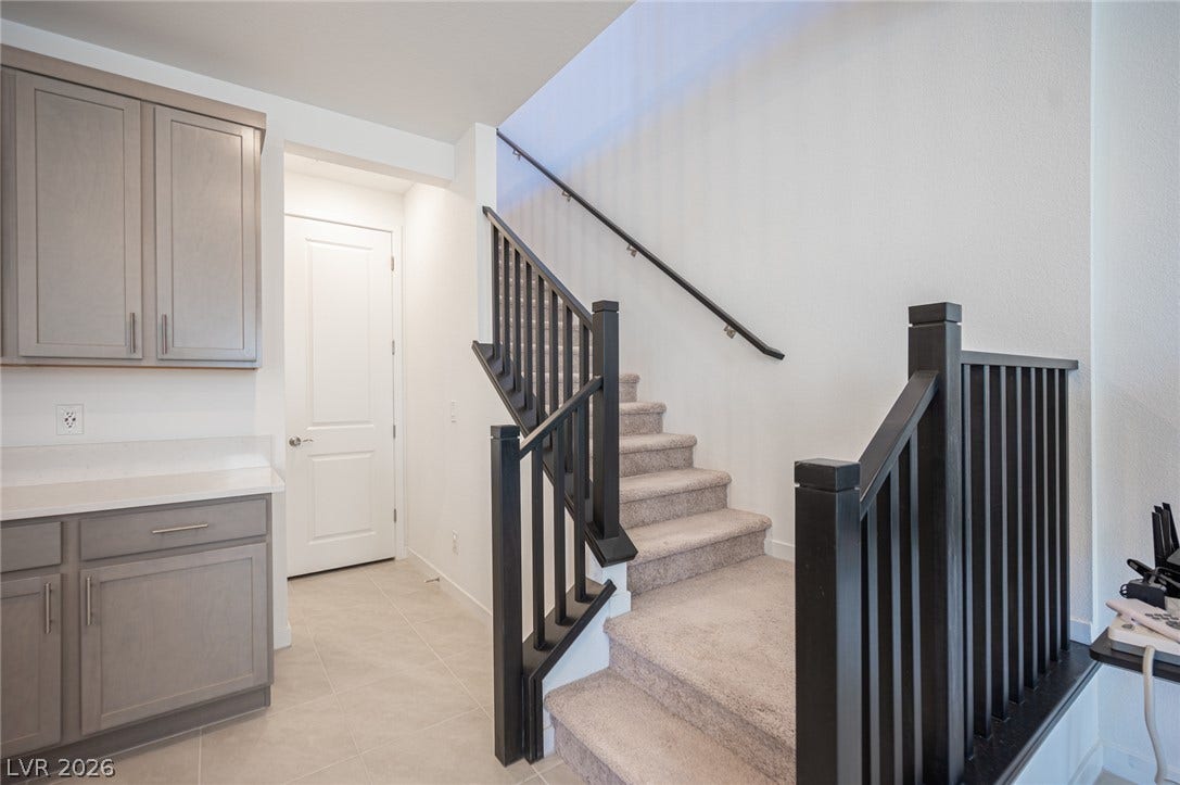2545 Monolith Street, Las Vegas, NV 89138 Carpeted stairs with dark wood railings transition seamlessly between home levels.