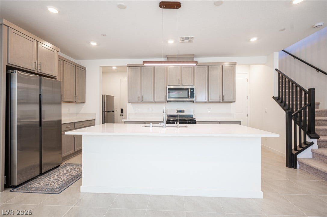 2545 Monolith Street, Las Vegas, NV 89138 An expansive central island anchors this modern culinary space featuring light tile flooring and recessed lighting.
