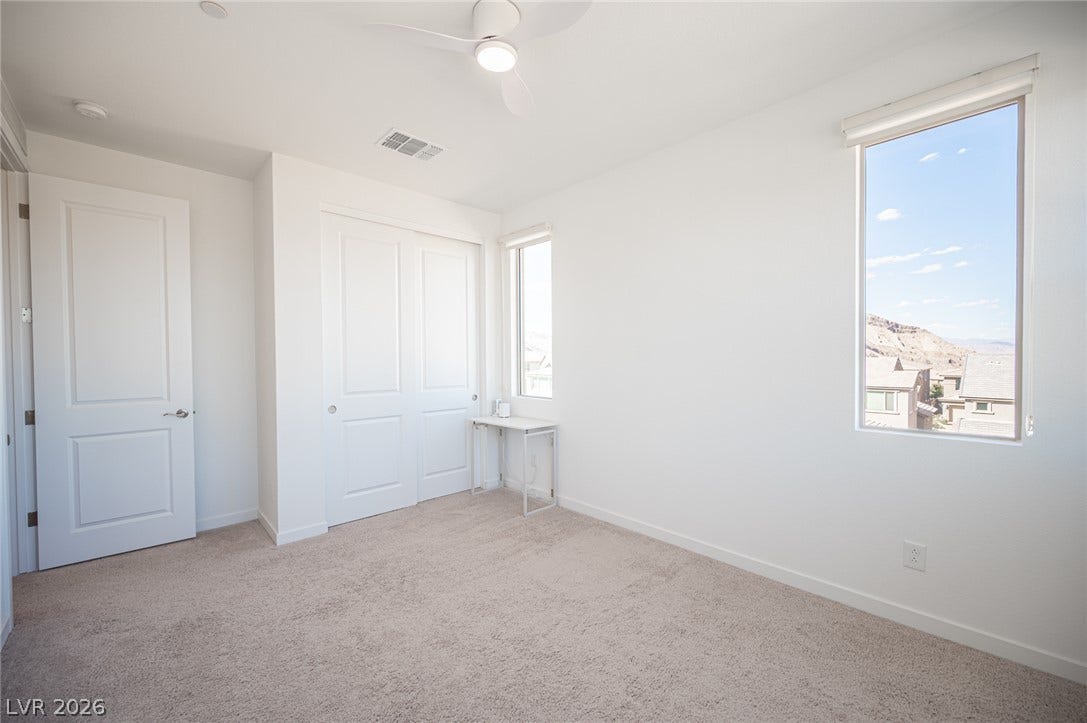 2545 Monolith Street, Las Vegas, NV 89138 Natural light fills this bedroom featuring carpet flooring and clean white walls.