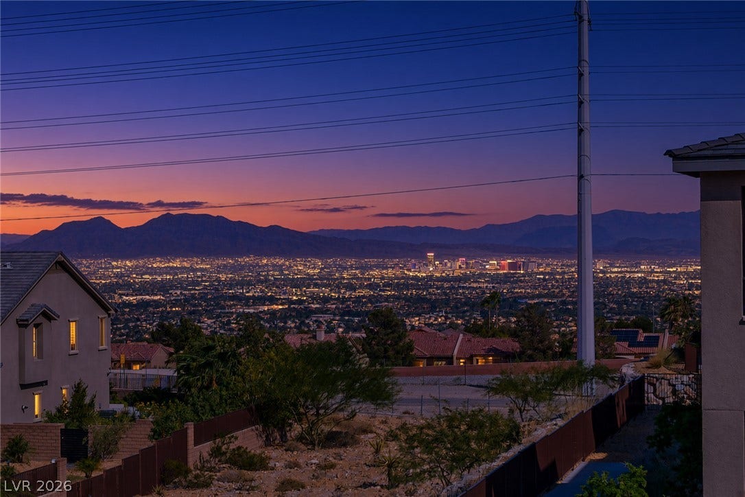 2545 Monolith Street, Las Vegas, NV 89138 Glimmering city lights and majestic mountain silhouettes create a dramatic backdrop at twilight.