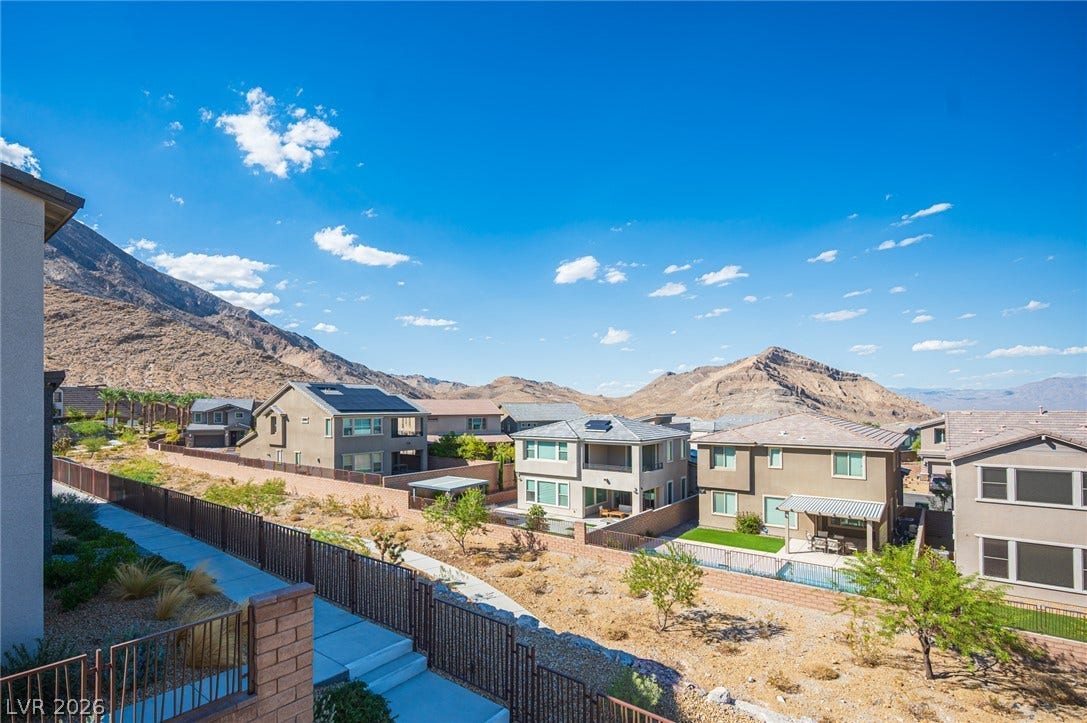 2545 Monolith Street, Las Vegas, NV 89138 Dramatic mountain peaks frame this elevated neighborhood view under a clear blue sky.
