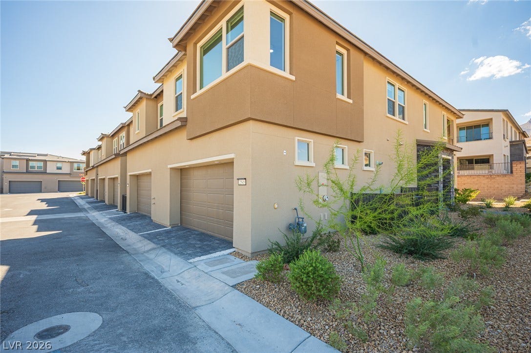 2545 Monolith Street, Las Vegas, NV 89138 Multi-level stucco townhome architecture incorporates attached garages and desert-friendly low-maintenance landscaping.