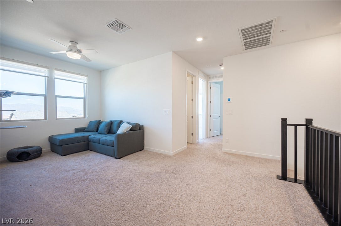 2545 Monolith Street, Las Vegas, NV 89138 A spacious upper-level loft features wall-to-wall carpeting and smooth neutral walls.