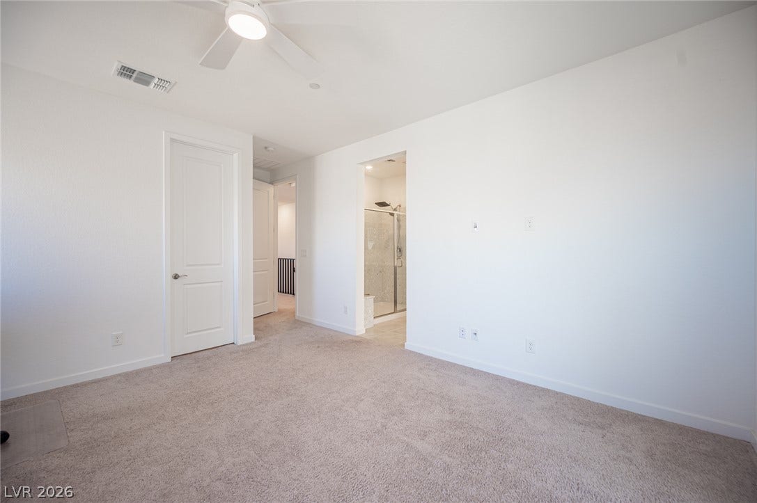 2545 Monolith Street, Las Vegas, NV 89138 Plush carpeting and clean white walls define this comfortable bedroom featuring an attached bath.