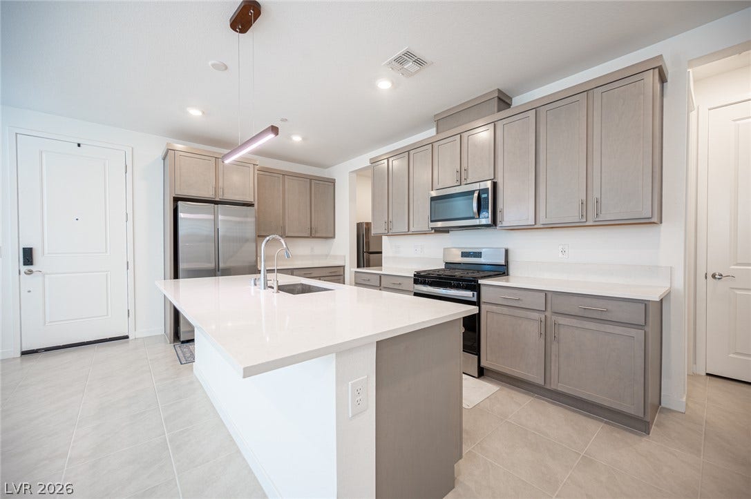 2545 Monolith Street, Las Vegas, NV 89138 Gleaming stone countertops and matching cabinetry anchor this modern kitchen space.