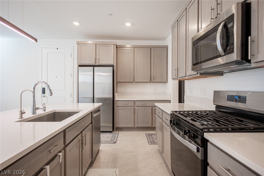 2545 Monolith Street, Las Vegas, NV 89138 Gleaming stone countertops and modern stainless steel appliances anchor this beautifully designed kitchen space.