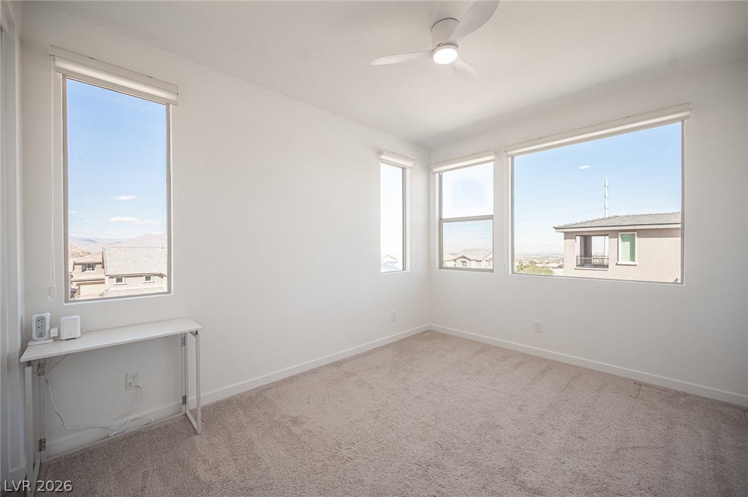 2545 Monolith Street, Las Vegas, NV 89138 Multiple windows frame neighborhood views in a carpeted room featuring clean white walls.