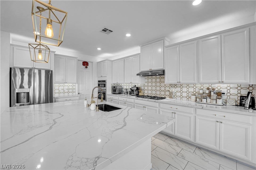 12415 Aster Hills Avenue, Las Vegas, NV 89138 Gleaming stone countertops and a spacious island anchor this light-filled culinary space.